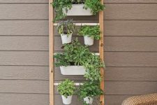 03 a ladder with metal holders and planters hanging on them, with herbs and greenery is a smart and cool solution for a space