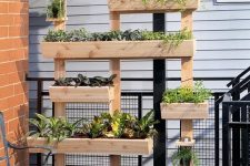 04 a non-stained wood vertical garden with multiple planters is a lovely idea for any outdoor space, a balcony, a terrace and many others