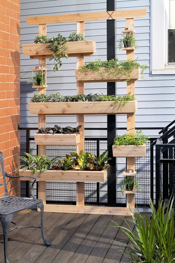 a non-stained wood vertical garden with multiple planters is a lovely idea for any outdoor space, a balcony, a terrace and many others