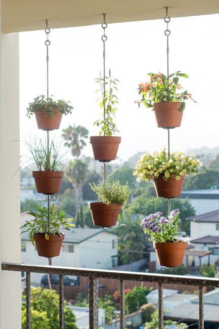 hooks with metal hangers and terracotta planters will beautifully dress up your small balcony without taking floor space