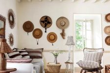10 a Mediterranean space with neutral decor, wooden and rattan items, hats on the wall that add coziness and interest to the space