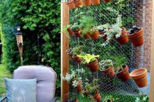 11 a cool and easy vertical garden composed of wood and chicken wire, with terracotta plants with herbs is a cool way to get a kitchen garden without sacrificing much space