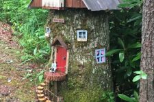 16 a tall tree stump with windows, a red door, a ladder of little wood slices and a large roof with a balcony is a fun gnome house