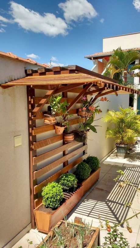 a simple and smart vertical garden of wood, with planters down and some additional planters attached to the planks above, plus a roof to hide the plants from excessive sunshine a simple and smart vertical garden of wood, with planters down and some additional planters attached to the planks above, plus a roof to hide the plants from excessive sunshine