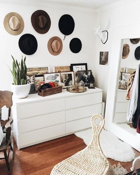 an IKEA dresser with artwork, potted plants, accessories, a gallery wall of hats over the space is a lovely idea for a modern closet