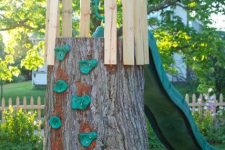 a climbing wall play set of a large tree stump, a slider and some wood and rope is a cool idea for a rustic outdoor space