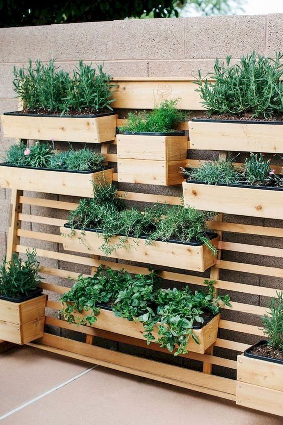 a lovely vertical garden for an outdoor space a small and smart wooden garden pf wooden planks, with wooden planters, greenery and herbs is a lovely idea for a modern rustic outdoor area