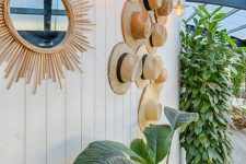 19 an outdoor wall decorated with straw hats that are attached to the wall and that give a light and airy feeling to the space