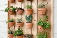 20 a stained wooden pallet with lots of terracotta planters and herbs is a lovely idea for a rustic space