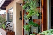 21 a vertical garden on chain, with blackened metal planters with herbs and names on them is a smart solution for a space with no garden