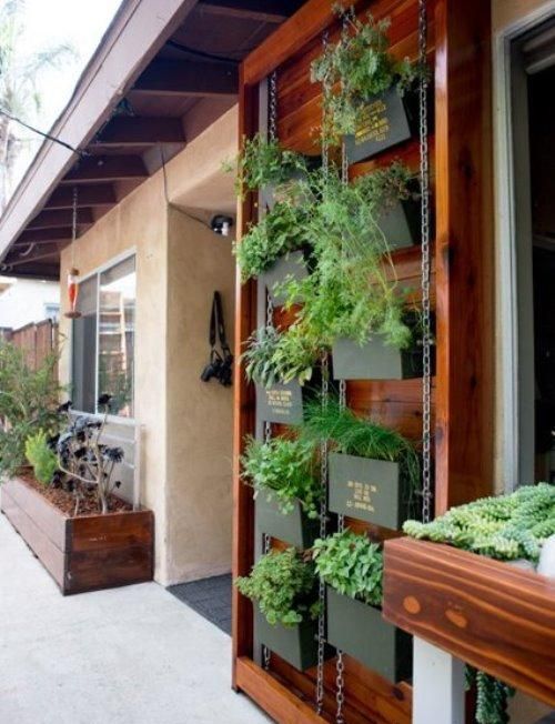 a vertical garden on chain, with blackened metal planters with herbs and names on them is a smart solution for a space with no garden a vertical garden on chain, with blackened metal planters with herbs and names on them is a smart solution for a space with no garden
