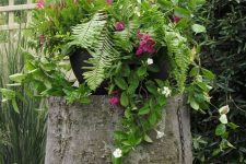22 a large tree stump as a planter stand, a large pot with greenery and bright blooms are amazing for styling a garden