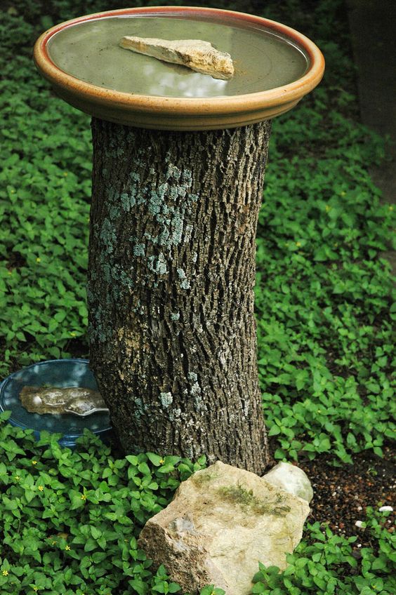 a bird bath stand made of an old tree stump and some rocks is a very cool idea that looks absolutely natural and is easy to make