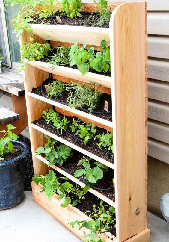 a vertical wooden planter with tiers is a lovely idea for growing herbs and plants and looks very cozy and rustic