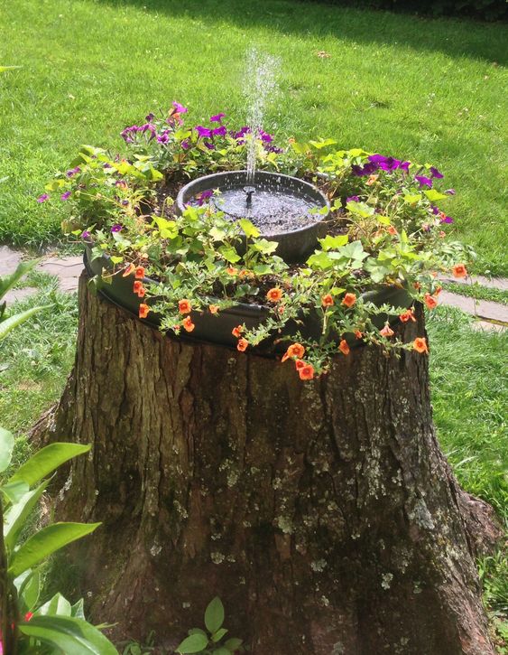 a tree stump rearranged into a planter stand with a fountain is a cool idea for adding a bright touch and a water sound to the space