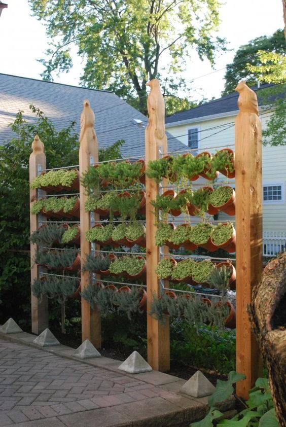 a wood and metal stand with lots of matching planters with greenery and herbs is a great idea for outdoors, you may build it anywhere