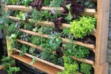 29 a wooden vertical garden with tiered planters and lots of herbs is a perfect solution if you have no space but want fresh herbs