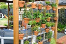30 add a metal grid with terracotta plants to your outdoor space and you will get a space divider and a herb garden in one