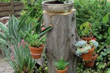 31 a tree stump with planters attached and a bowl on top is a gorgeous planter stand to rock, looks nice and unusual