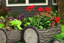 34 tree stumps with greenery and bright blooms placed on the grass are a great all-natural alternative to a usual planter