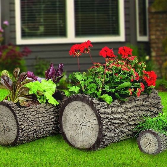 tree stumps with greenery and bright blooms placed on the grass are a great all natural alternative to a usual planter