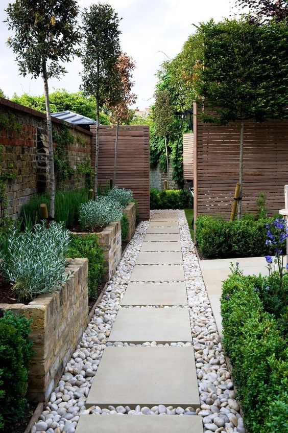 tall brick garden beds with greenery, trees in between them and some greenery around the entrance are a great combo if you have literally no space for the garden