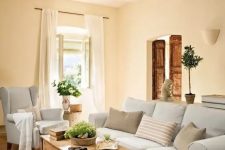a farmhouse chic living room with neutral furniture, a jute rug and a low coffee table of stained wood
