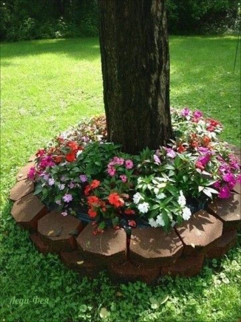 a raised garden bed clad with rocks, with bold and neutral blooms and greenery under it is a lovely idea for many gardens