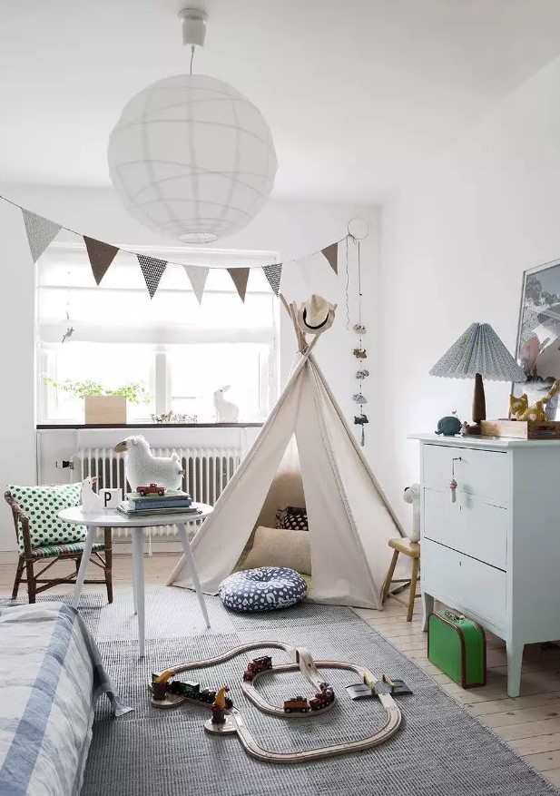 a serene Scandinavian kid's room with a bunting, a teepee, a dresser, some wooden furniture, a bed and some cute toys