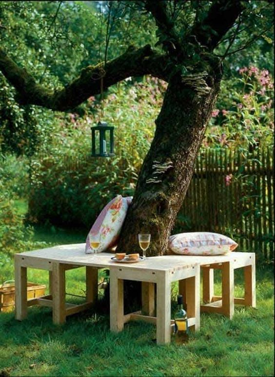 a simple stained bench around the tree, with pillows and some food is a lovely space to enjoy some meals, drinks and rest
