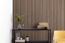 22 a minimalist space with a wooden slat accent wall, a black shelving unit, a yellow chair and some boxes is amazing