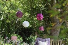 25 a wooden bench wrapping the tree, with purple blankets, cushions and pillows, paper pompoms and hanging lanterns