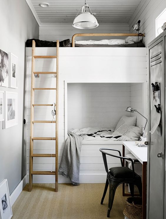 a small and lovely shared kids' room with a planked bunk bed, black and white bedding, a desk, a black chair and retro lamps