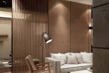 37 a modern living room with a wooden wall, the part of which is ofslats that create a space divider