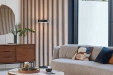 39 an elegant mid-century modern living room with a wood slat accent wall and ceiling, a curved sofa, a printed rug, a stained credenza and a coffee tabl