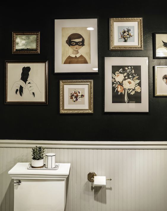 a black and white bathroom with wallpaneling, white appliances and a catchy monochromatic gallery wall