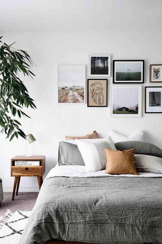 a contemporary gallery wall with a free form and mismatching frames plus prints and artworks that give it a modern feel