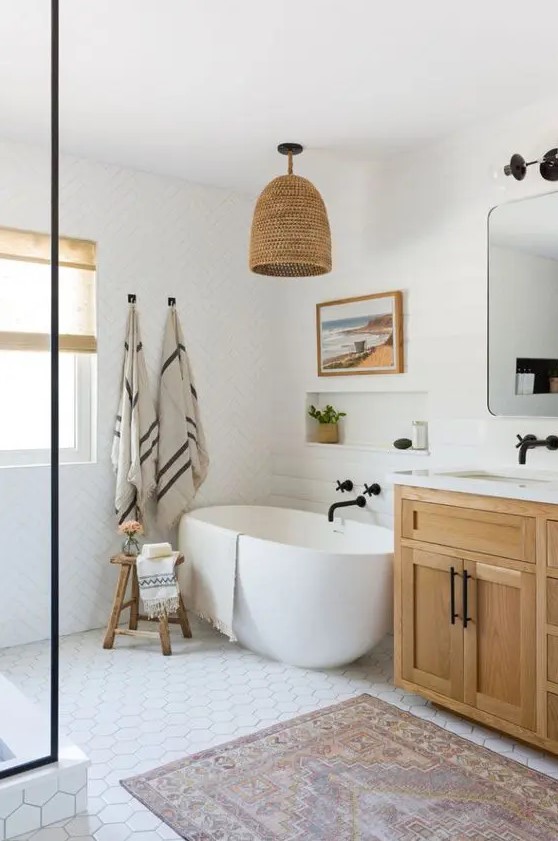 a modern country bathroom with white mismatching tiles, a stained vanity, white appliances, black fixtures and a woven lampshade