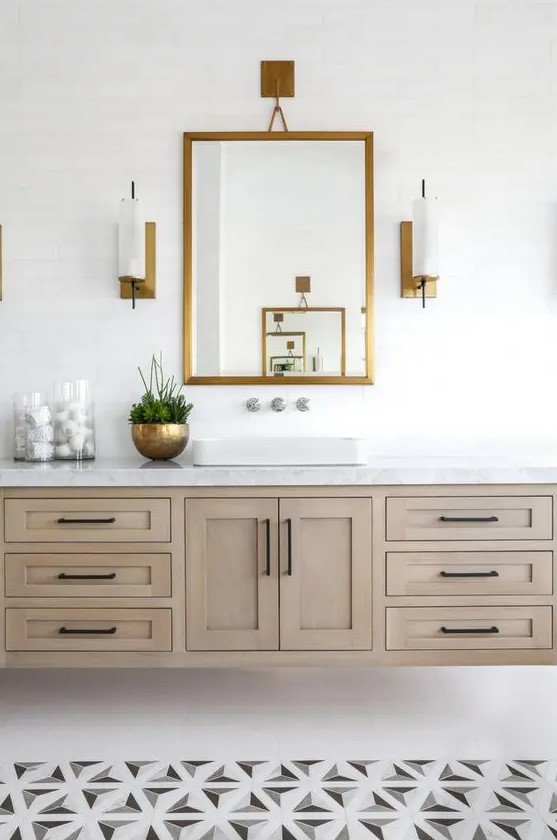a modern farmhouse bathroom with geometric tiles on the floor, a large wooden floating vanity and a mirror