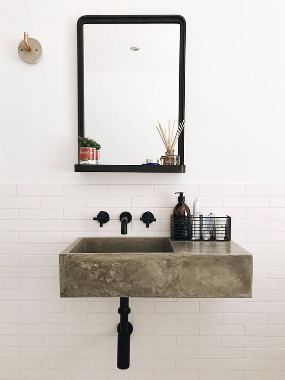 a polished concrete floating sink, black fixtures and a mirror in a black frame for a chic and beautiful bathroom look in modern style