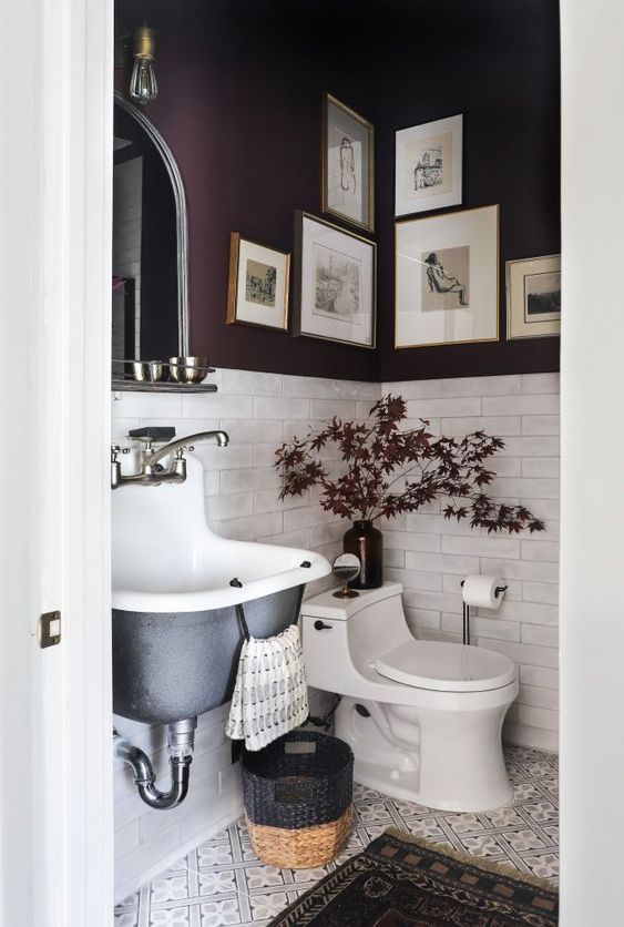 a refined moody mudroom with purple walls and white tiles, a black wall-mounted sink, a basket and some bulbs and lights