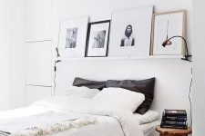 a relaxing Scandinavian bedroom with a bed with neutral bedding, stained nightstands, a simple ledge gallery wall