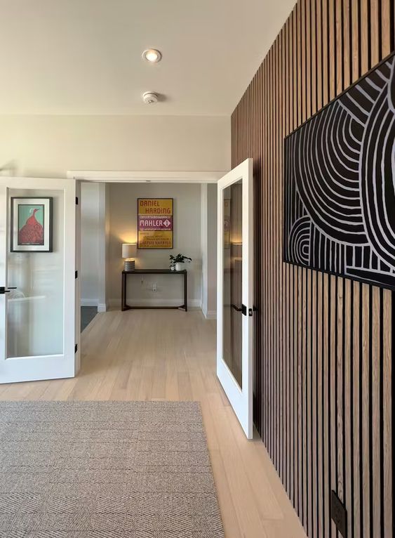 a rich-stained wood slat accent wall with a matching artwork is a nice alternative to a blank white wall, and it looks pretty nice
