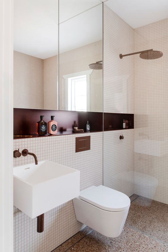 a small and chic modern bathroom with small scale tiles, a mirror cabinet, a burgundy niche shelf and a floating sink