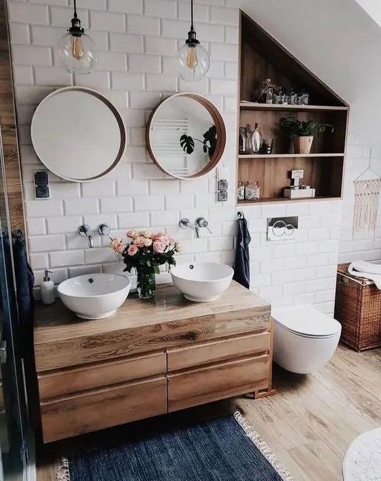 a small and cozy bathroom clad with white subway tiles, a floating vanity and a niche done with wood plus white appliances