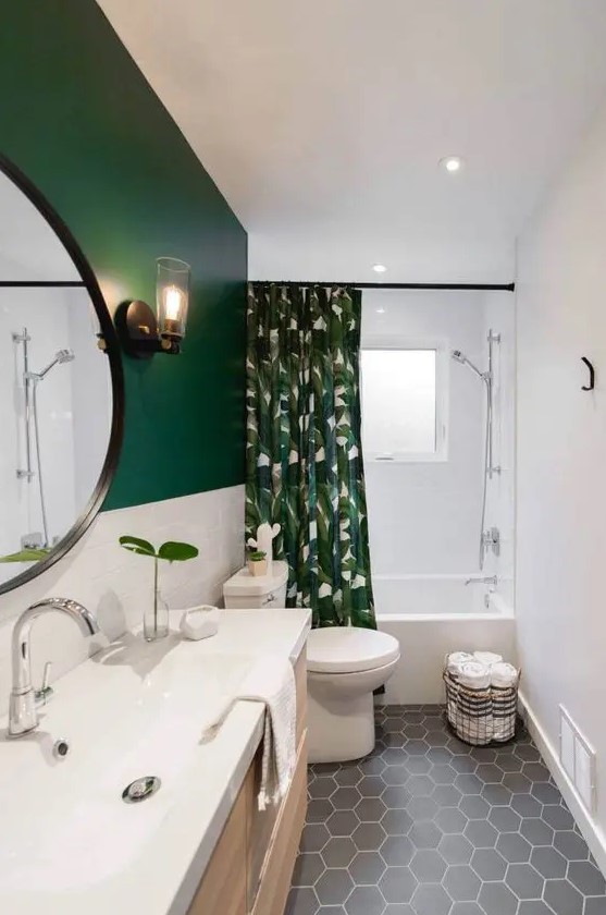a stylish small bathroom with a green and white tile wall, a grey hex tile floor, a floating timber vanity and a tropical print curtain