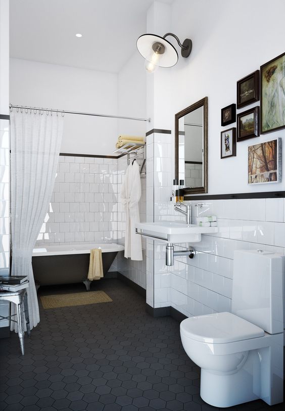 a vintage bathroom with a black hex tile floor, planked walls and white square tiles, a black clawfoot tub, a gallery wall and a floating sink is chic