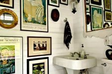 a white farmhouse bathroom with a vintage gallery wlal, a mirror, white appliances and black towels is a chic space