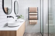an airy Scandinavian bathroom with skinny white and marble tiles, a shower zone, a double vanity and black touches