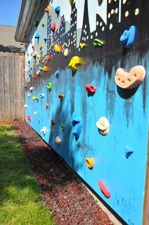 a house wall turned into a colorful climbing wall and with a bold wall art is a lovely idea that will make your kids happy